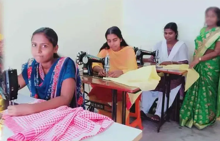 Young women sew at sewing machines in a bright room, one with pink checked cloth in front of her, India.