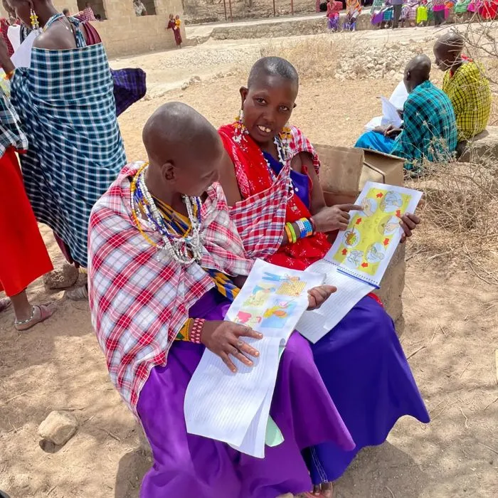 Two women studying a Pioneer Business Planting training manual